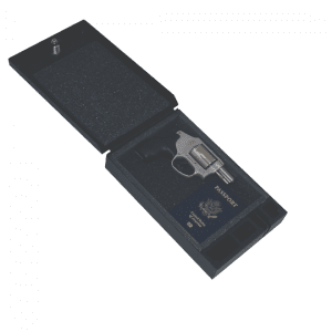 An open Tuffy portable safe with a foam-lined interior containing a handgun and a U.S. passport, demonstrating secure storage for valuables.